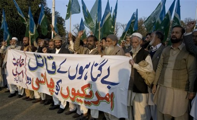 Supporters of Pakistani religious party Jamat-e-Islami chant slogans behind a banner reading, "hang the American killer of innocents," during a demonstration Sunday in Islamabad. The United States has demanded the immediate release of an American official arrested in the shooting deaths of two Pakistanis, but a Pakistani court on Tuesday blocked his release.